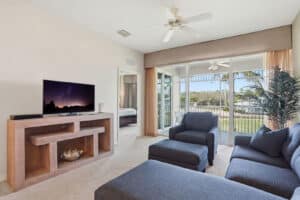 Living room opening to a lanai with golf course views at Lely Resort, Naples