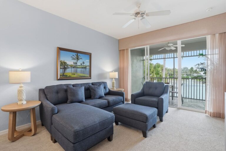 Living room with screened lanai access and a lake view in a Naples vacation rental