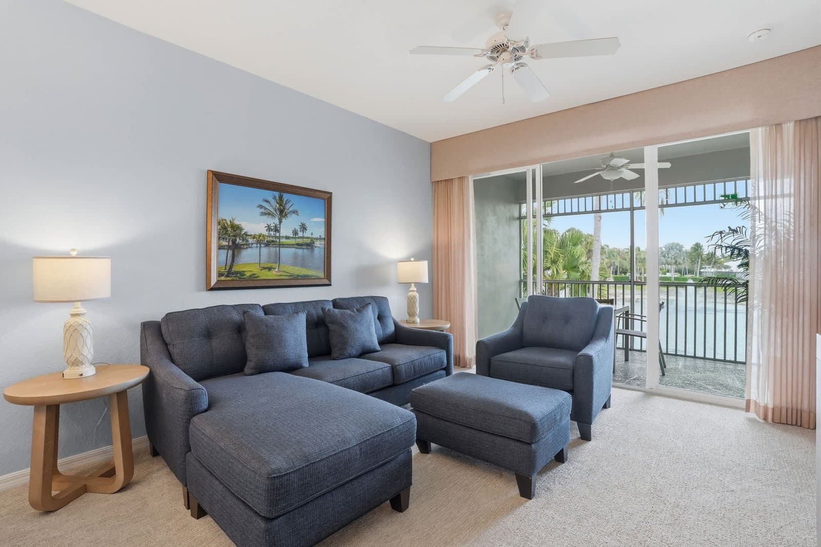 Living room with screened lanai access and a lake view in a Naples vacation rental