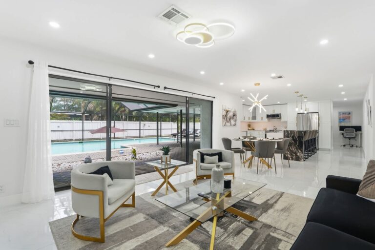 Modern living and dining room with a pool view in a Naples vacation rental